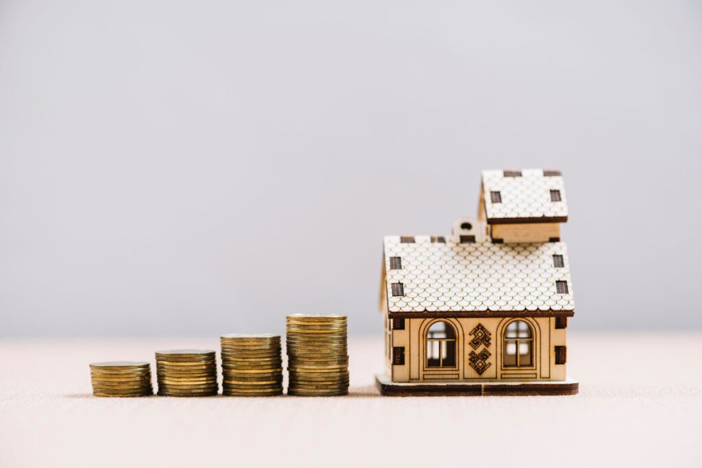 Wooden miniature house with coins, illustrating the concept of receiving a rent lump sum.